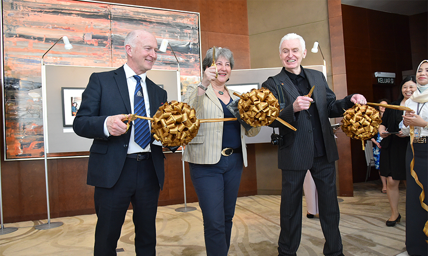 Professor Nigel Weatherill and Mike McCartney about to cut a golden ribbon to declare the exhibition open