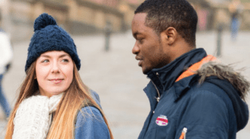 two students look in discussion outside about